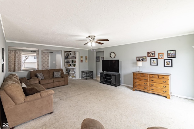 carpeted living area featuring baseboards, a textured ceiling, ceiling fan, and crown molding