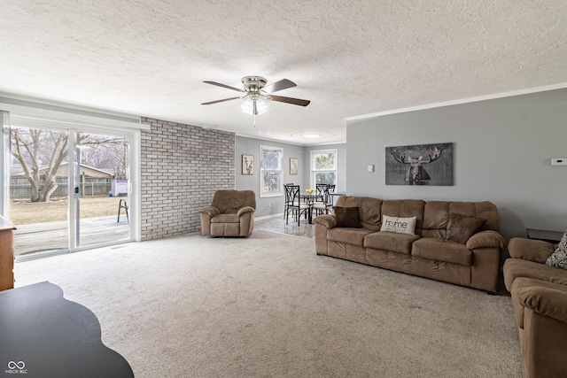 living room featuring a textured ceiling, ceiling fan, carpet flooring, and ornamental molding