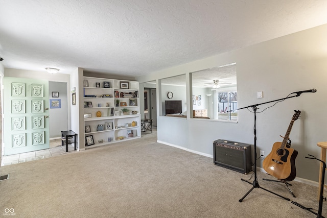 living area with a ceiling fan, visible vents, baseboards, a textured ceiling, and carpet flooring