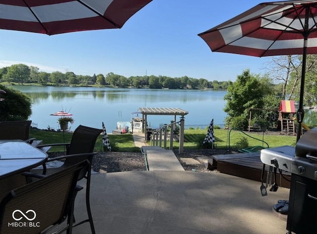 view of patio with a grill, a pergola, and a water view