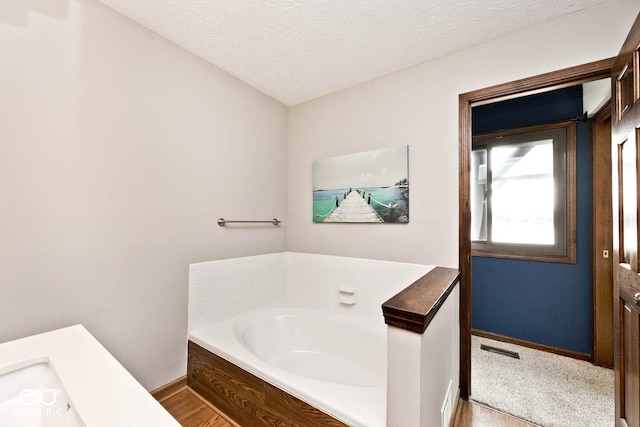 bathroom with a bathtub and a textured ceiling