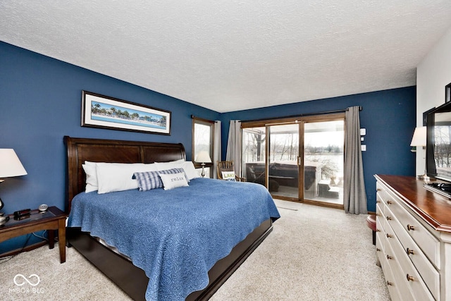 carpeted bedroom with access to outside and a textured ceiling