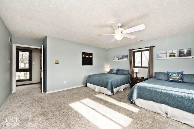 bedroom with a textured ceiling, ceiling fan, and carpet flooring