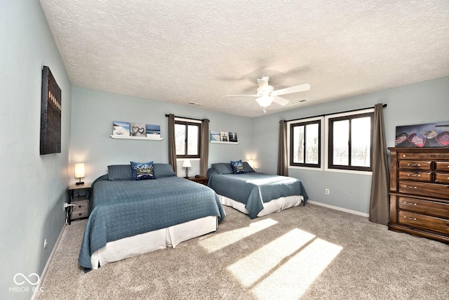 carpeted bedroom with ceiling fan and a textured ceiling