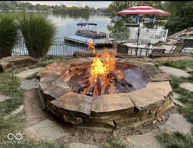 exterior space featuring a water view and a fire pit