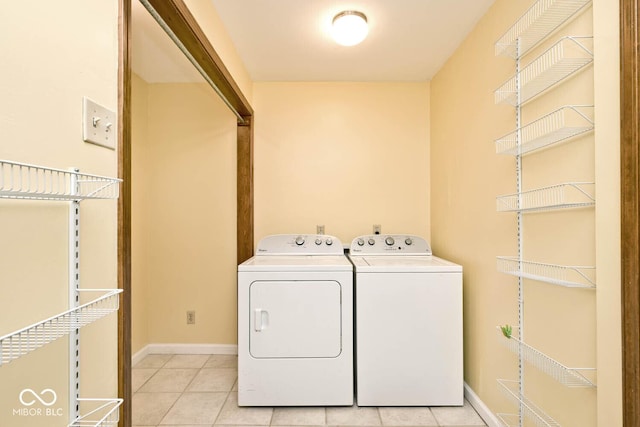 washroom with washer and dryer, baseboards, laundry area, and light tile patterned floors