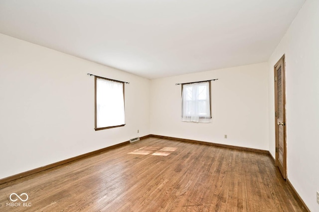 spare room featuring baseboards and wood finished floors