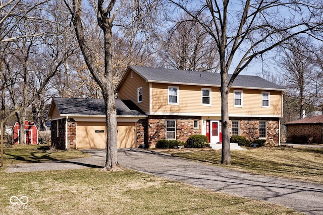 colonial inspired home featuring driveway, a front lawn, and an attached garage