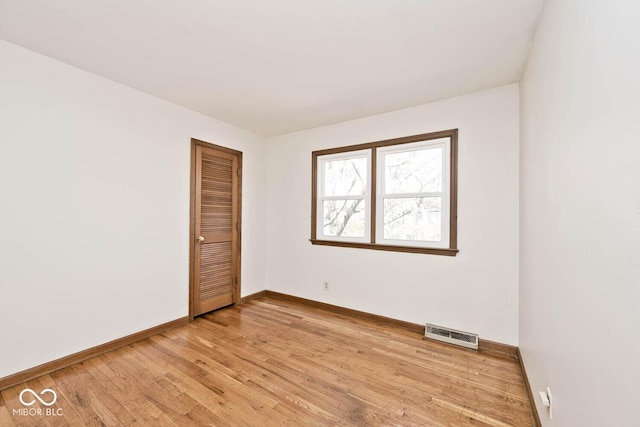 unfurnished room featuring baseboards, visible vents, and light wood finished floors