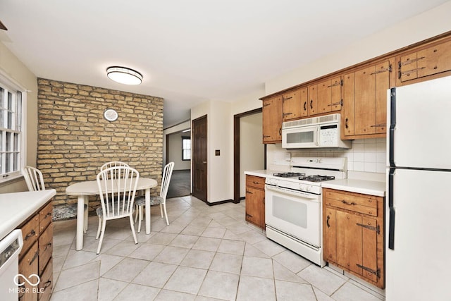 kitchen featuring white appliances, light countertops, brown cabinets, and backsplash