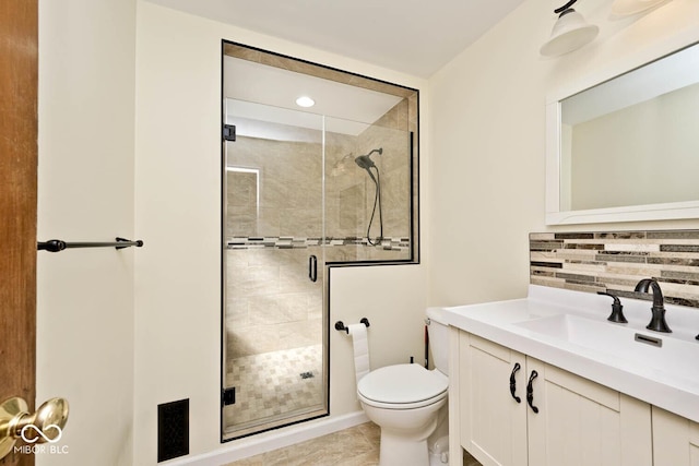 bathroom with backsplash, a stall shower, toilet, and vanity