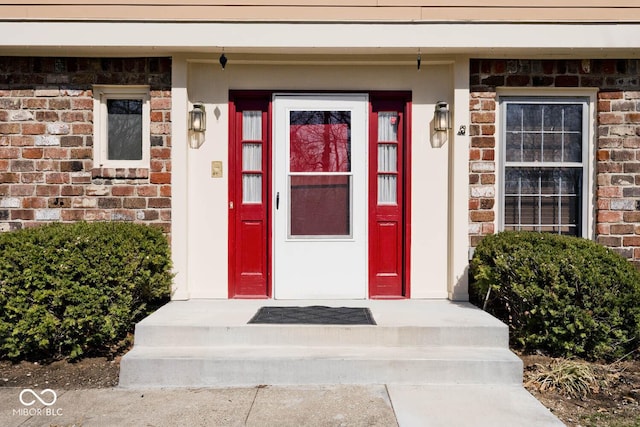 doorway to property featuring brick siding