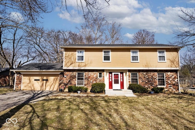 colonial house with brick siding, an attached garage, driveway, and a front yard