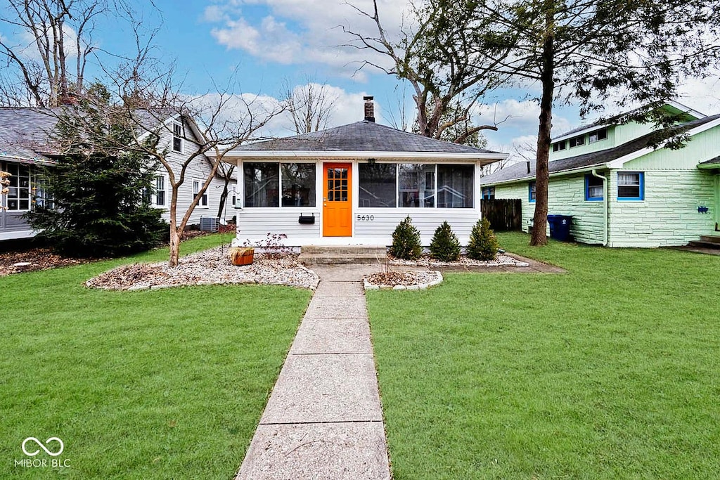 view of front of property with cooling unit, a front yard, and a sunroom