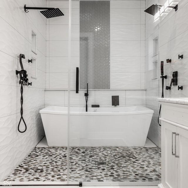 bathroom with tile walls, vanity, and separate shower and tub