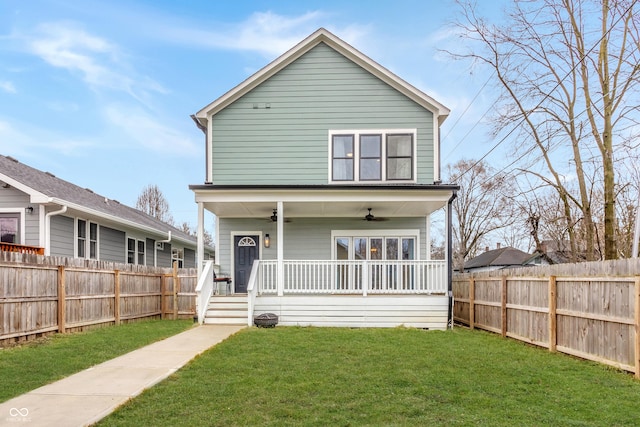 rear view of property with ceiling fan, covered porch, and a lawn