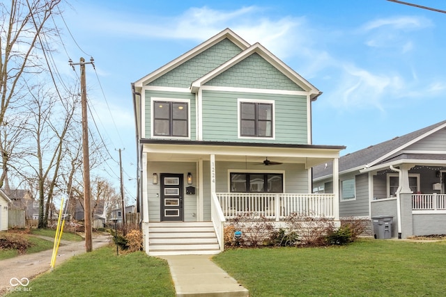 view of front of house with ceiling fan, a porch, and a front yard