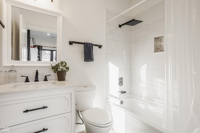 full bathroom featuring vanity, tiled shower / bath combo, and toilet