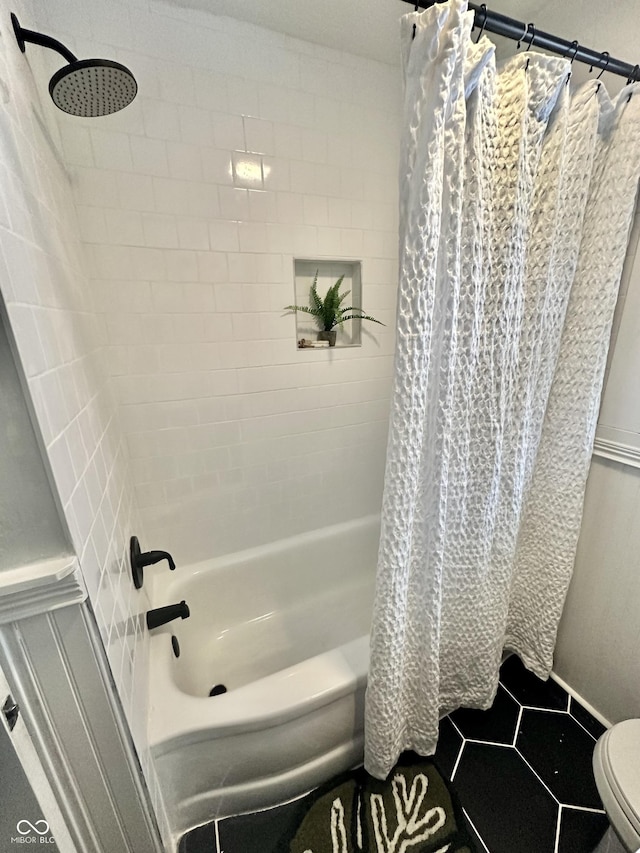 bathroom featuring tile patterned flooring, shower / tub combo, and toilet