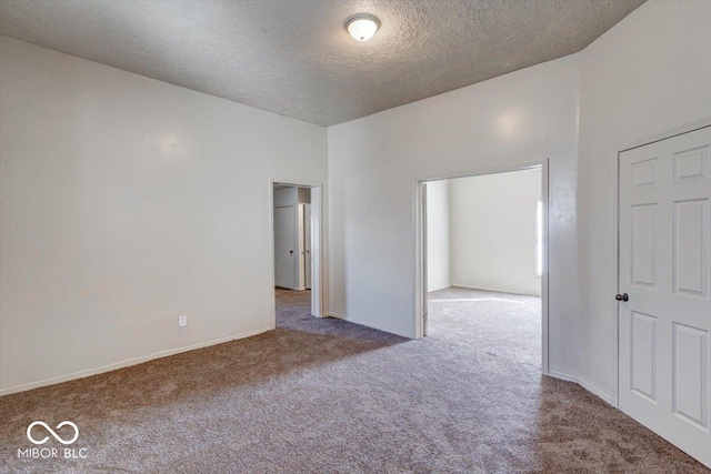 empty room featuring a textured ceiling and carpet