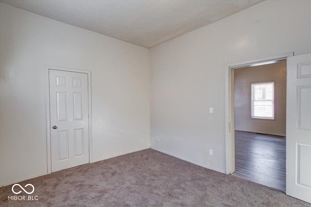 spare room with light carpet and a textured ceiling