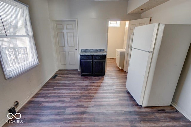 kitchen with white fridge, dark wood-type flooring, and a wealth of natural light