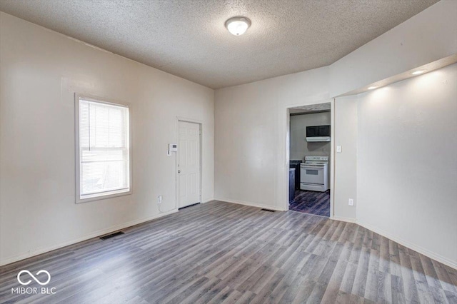 spare room with dark hardwood / wood-style flooring and a textured ceiling