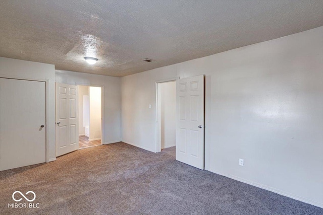 carpeted spare room featuring a textured ceiling