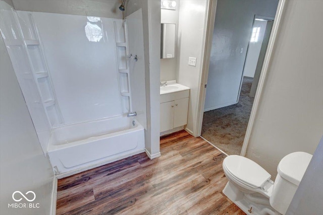 full bathroom with hardwood / wood-style flooring, vanity, shower / bathtub combination, and toilet