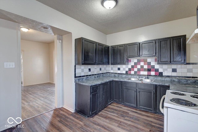 kitchen featuring sink, dark wood-type flooring, white electric range oven, a textured ceiling, and decorative backsplash