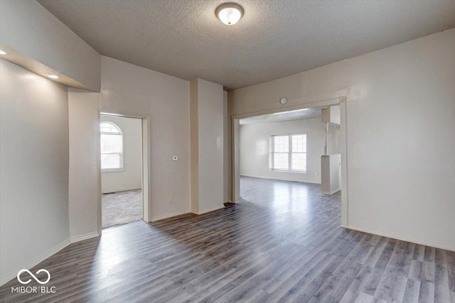 empty room with wood-type flooring and a textured ceiling