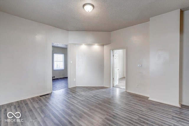 empty room featuring hardwood / wood-style flooring and a textured ceiling