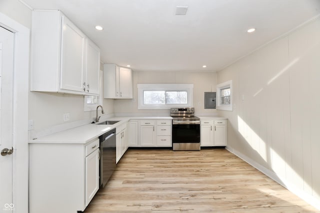 kitchen with stainless steel appliances, white cabinetry, sink, and a wealth of natural light