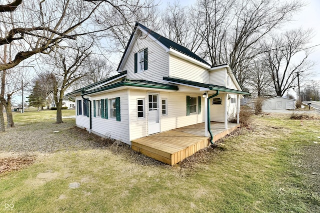 back of property featuring a wooden deck and a lawn