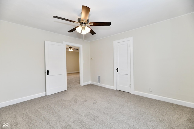 empty room featuring ceiling fan and light carpet