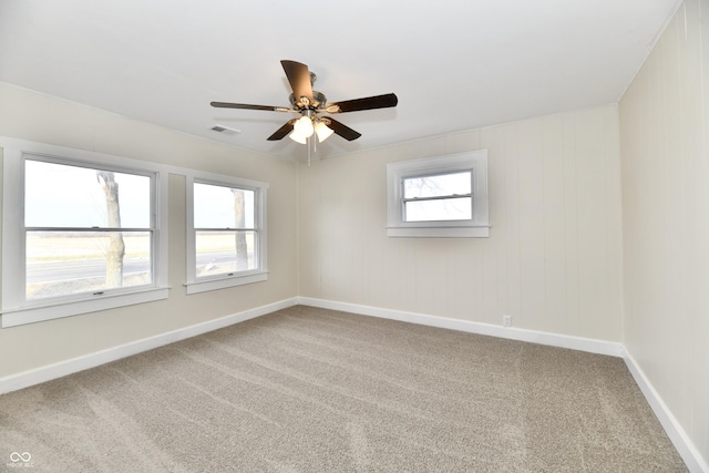 carpeted empty room featuring ceiling fan and plenty of natural light