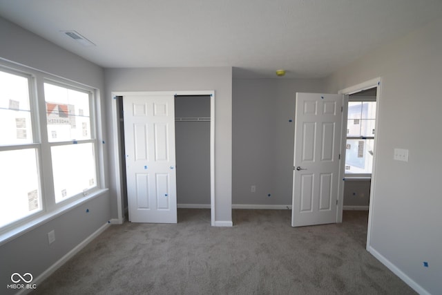 unfurnished bedroom featuring a closet, carpet, visible vents, and baseboards