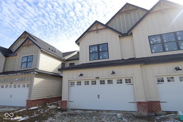 view of side of home with board and batten siding, brick siding, and a garage