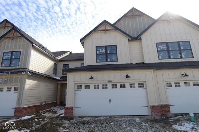 view of front facade featuring an attached garage, board and batten siding, and gravel driveway