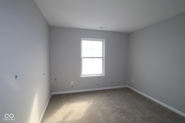 carpeted spare room featuring visible vents and baseboards