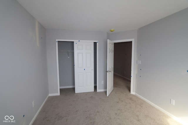 unfurnished bedroom with carpet floors, baseboards, and a closet