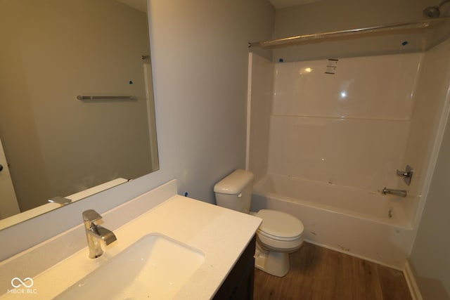 full bathroom featuring washtub / shower combination, vanity, wood finished floors, and toilet