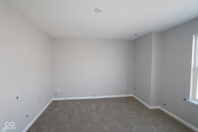 spare room with baseboards and carpet flooring