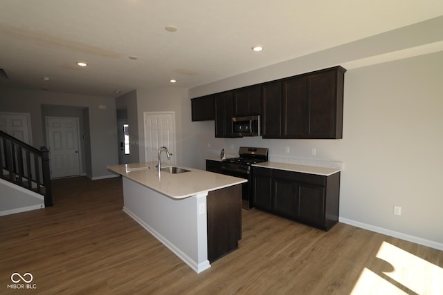 kitchen with light wood finished floors, recessed lighting, stainless steel appliances, and a sink