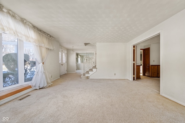 carpeted spare room with a notable chandelier