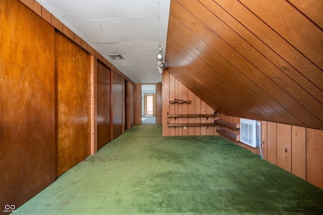 bonus room with carpet floors, vaulted ceiling, and wood walls