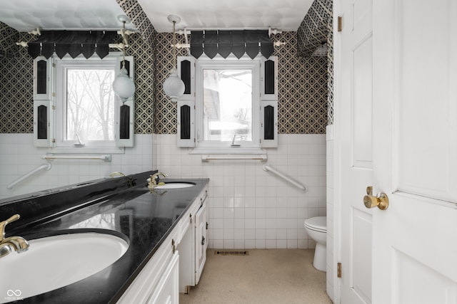 bathroom featuring tile walls, vanity, and toilet