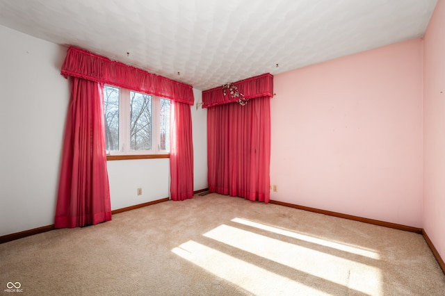 spare room featuring light carpet