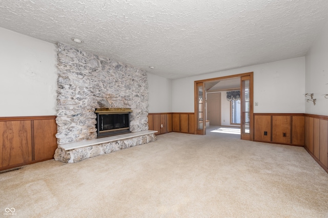 living room with light colored carpet, a textured ceiling, and a fireplace