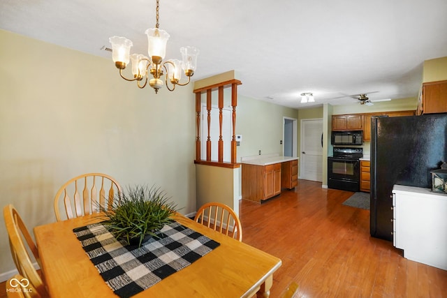 dining room with ceiling fan with notable chandelier and light wood-type flooring